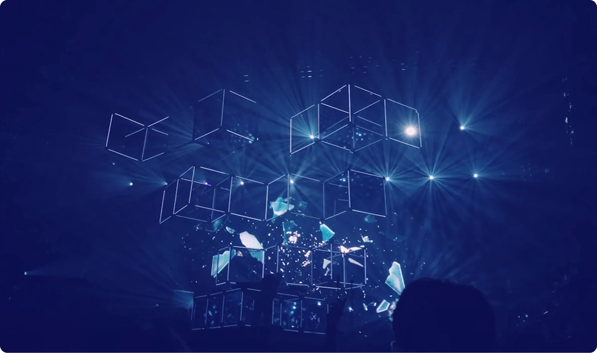Wireframe cubes over a teal-lit stage.