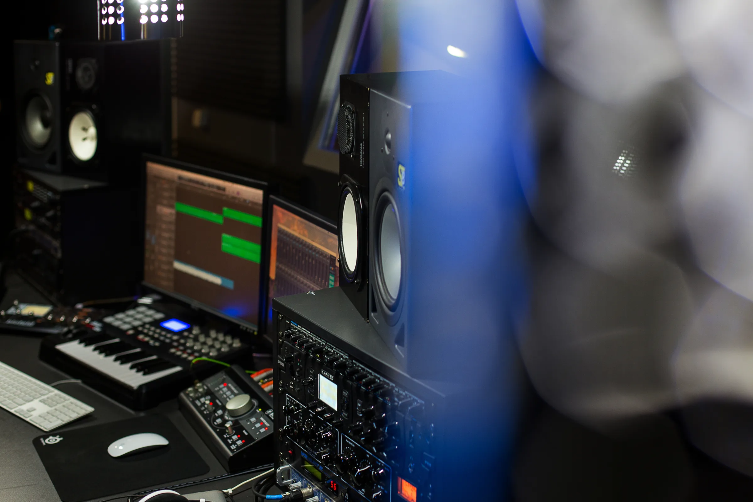 Audio rack, studio monitors, and DAW screens in a music studio.